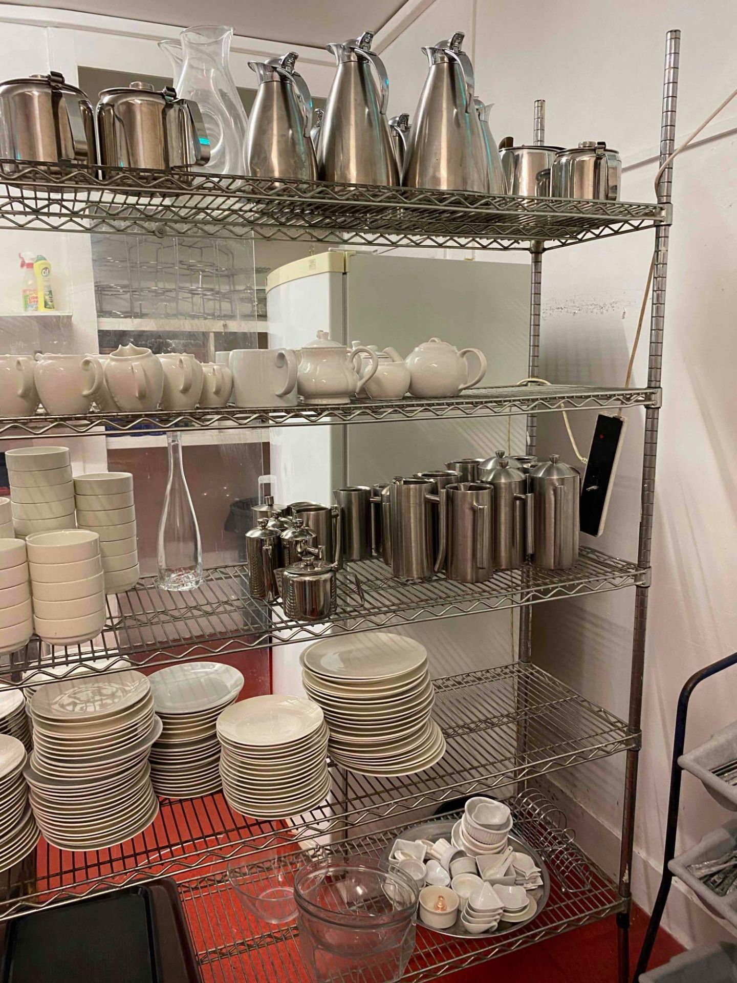 Content of fourth shelf of metal kitchen racking. As found to include tea pots and milk jugs. - Image 2 of 2