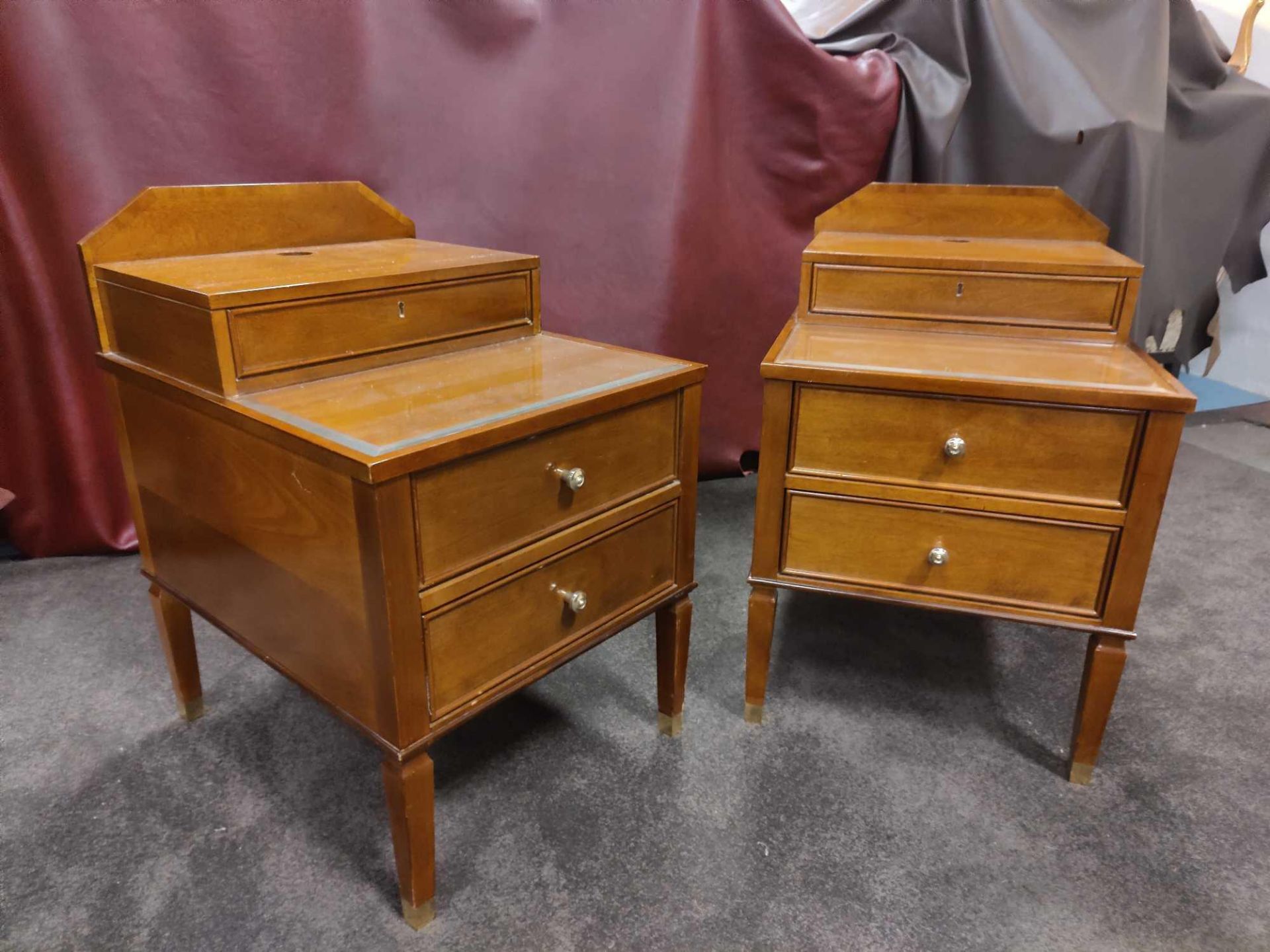 A Pair Of Two Tier Bedside Nightstands With Plate Top With Storage Compartments Mounted On Tapered