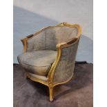 A Giltwood Framed Upholstered Bergere Chair With Carved Decorative Ornamentation To The Back Rail