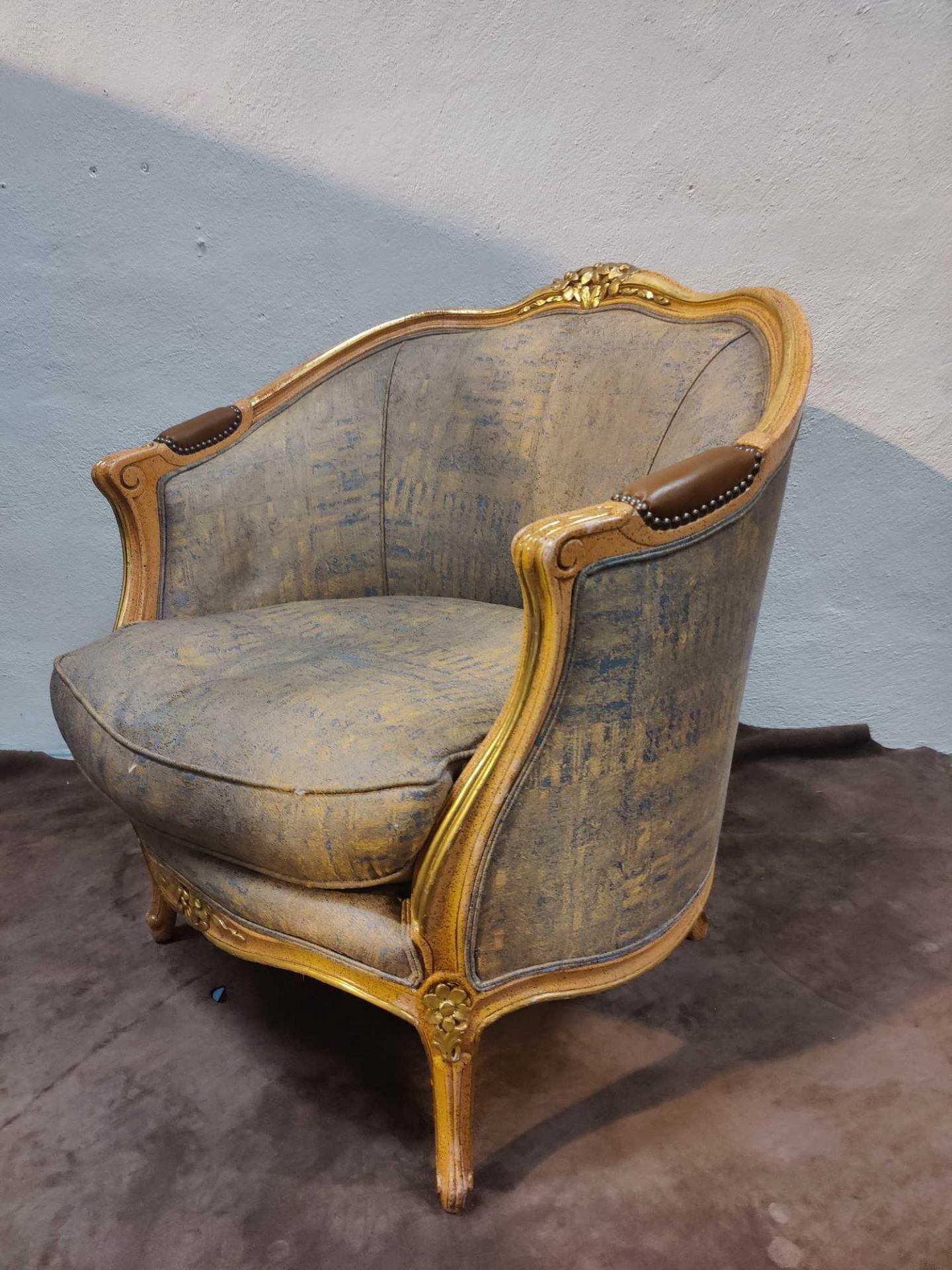 A Giltwood Framed Upholstered Bergere Chair With Carved Decorative Ornamentation To The Back Rail