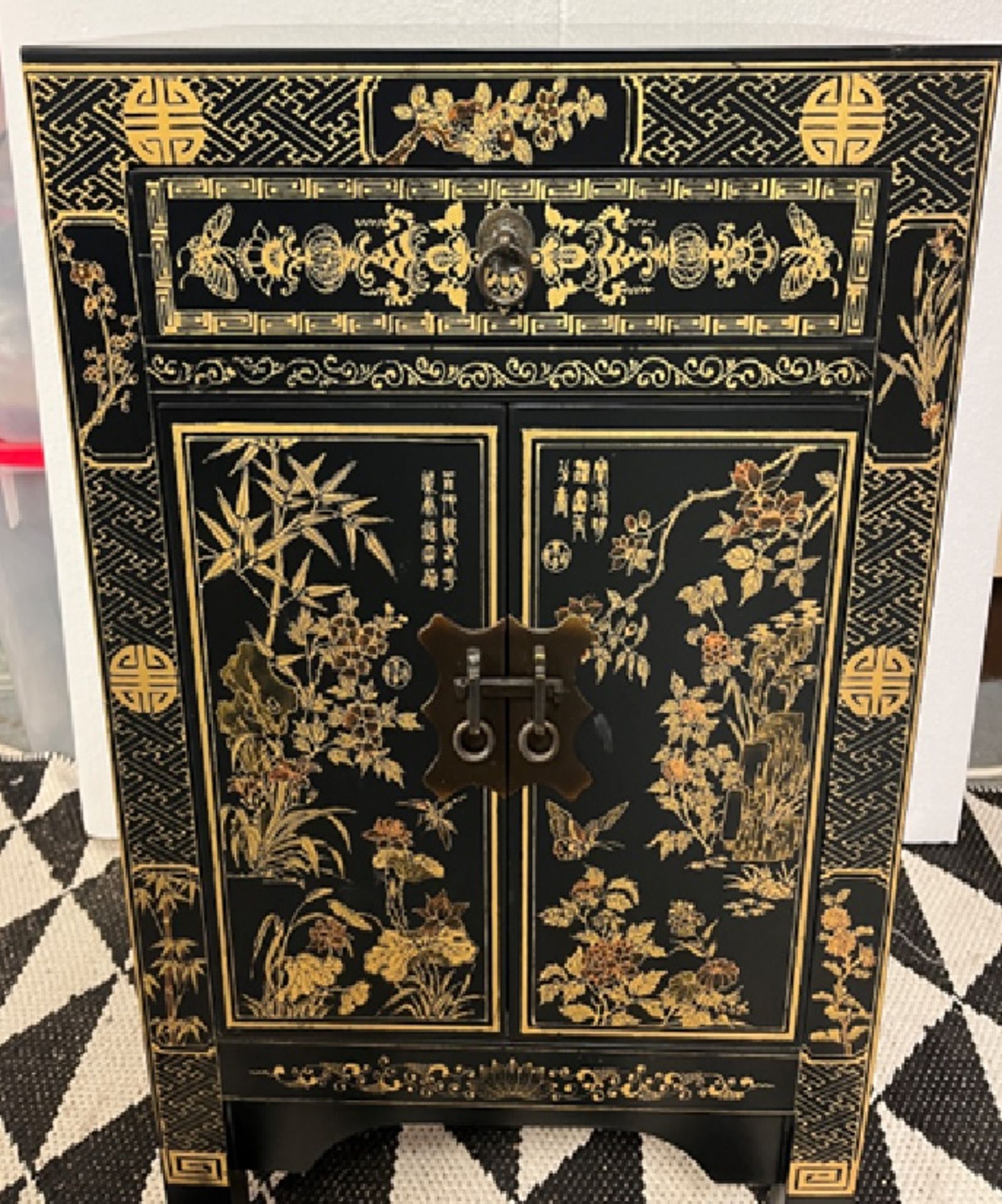 Chinese Lacquered Side Cabinet The cabinet has figurative panels on the front in lacquered gold