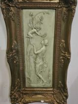 A Framed Stone Plaque Depicting  In Relief A Nymph And A Winged Fairy Framed, In A Green Hue