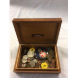 WOODEN CIGARETTE BOX WITH PISTOL EMBELLISHMENT WITH MISC FOREIGN COINS