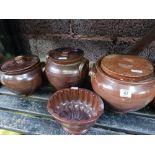 SHELF OF LIDDED EARTHENWARE & A JELLY MOULD