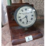 A VINTAGE DASHBOARD CLOCK BY NICOLE NIELSEN & CO LTD MOUNTED ON A WOODEN STAND