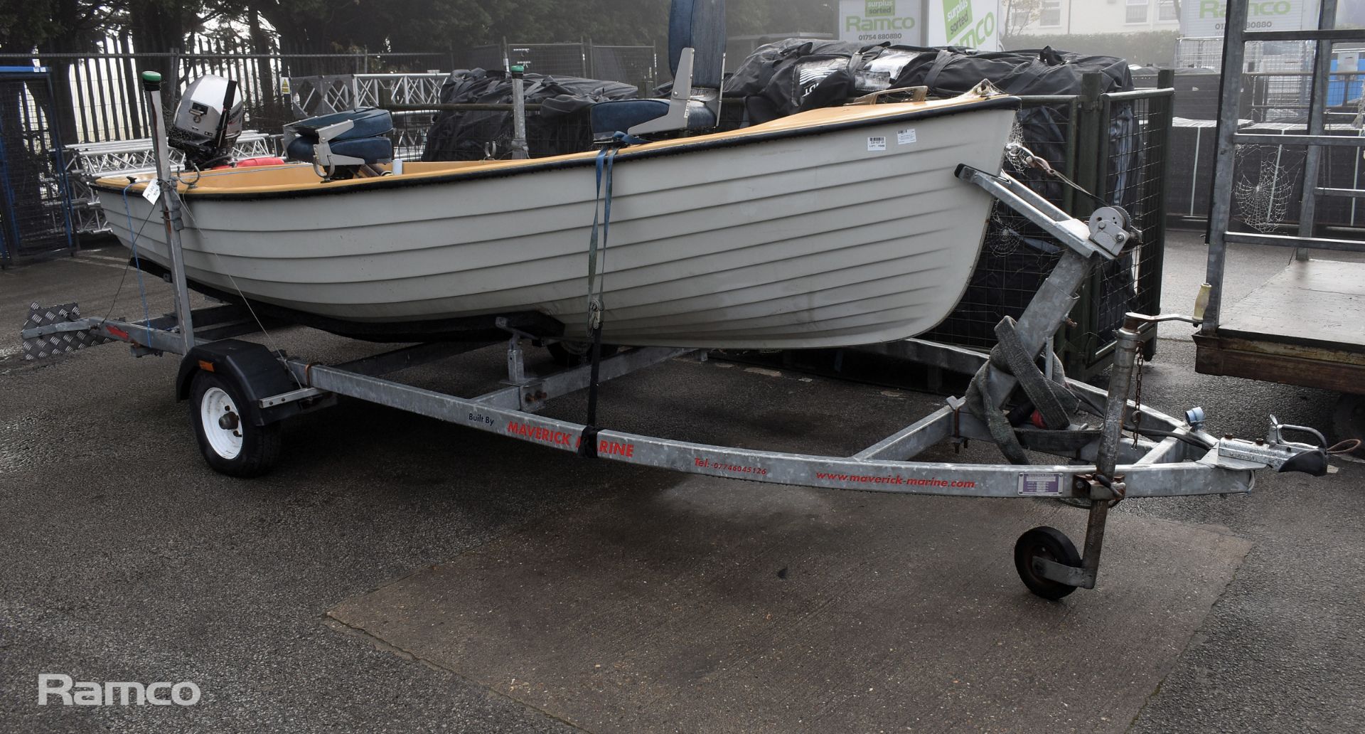 Unbranded boat with Mariner 9.9 Four Stroke outboard motor model 7F10211ZA on trailer