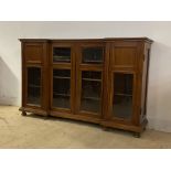 An Edwardian mahogany inverted break front bookcase, the centre twin doors enclosing three