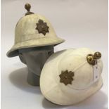 Two Royal Marine pith helmets. One dated 1953 (Hobson & Sons), the other of later manufacture.