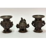 A Chinese bronze late 19thc garniture set including a pair of baluster vases raised on tripod