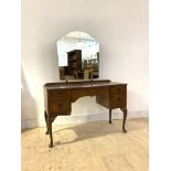 A Queen Anne style walnut dressing table, early 20th century, the swing mirror over bowed centre