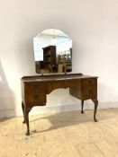 A Queen Anne style walnut dressing table, early 20th century, the swing mirror over bowed centre