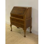 A Queen Anne style figured walnut bureau, the fall front enclosing fitted interior, over three