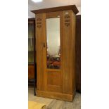 An early 20th century Glasgow school Arts and Crafts oak wardrobe, the projecting cornice over