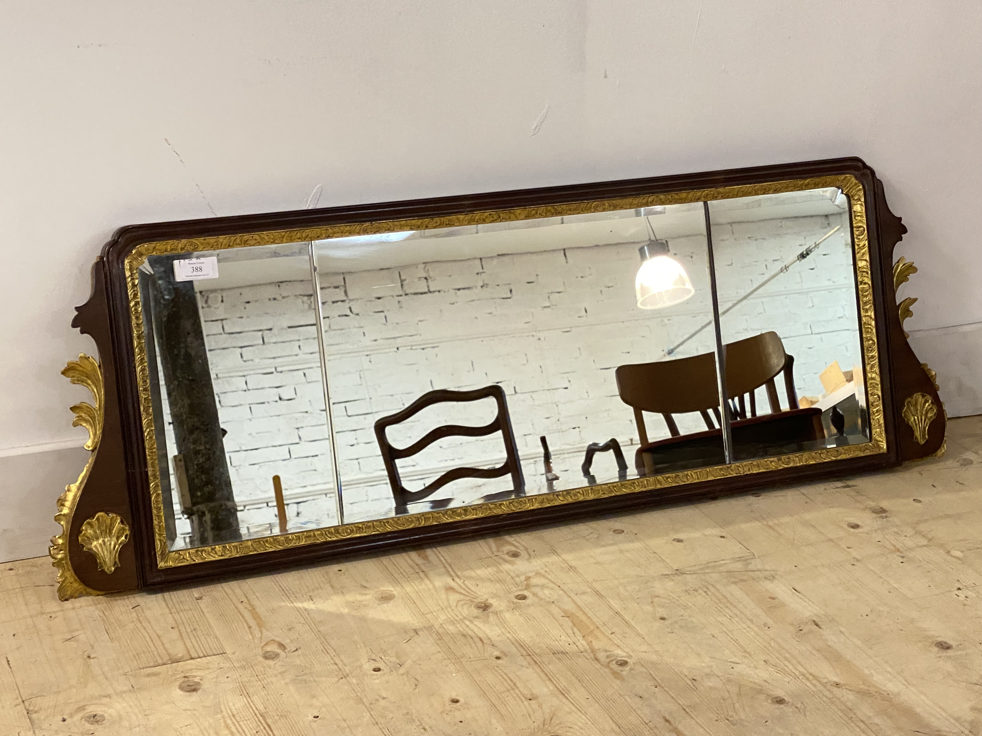 A 1930's parcel gilt walnut framed sectional bevelled glazed mirror of 18th century design, 126cm