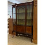 An Edwardian inlaid mahogany display cabinet, the serpentine front with astragal glazed door