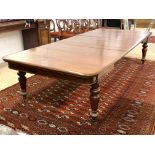 A large Victorian mahogany extending dining table, the top pulling out to house five leaves, (some