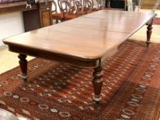 A large Victorian mahogany extending dining table, the top pulling out to house five leaves, (some