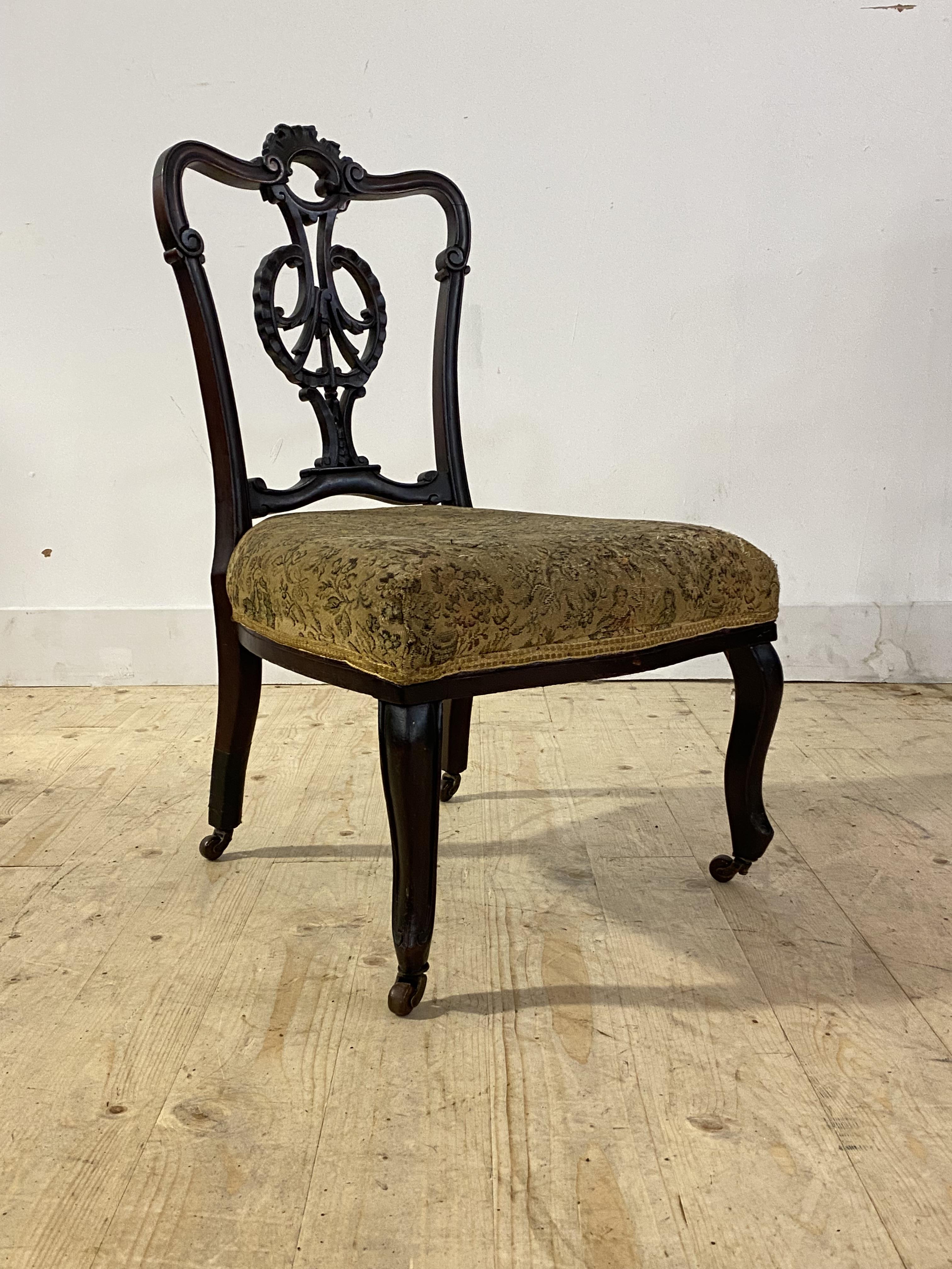 A Victorian mahogany salon chair with floral carved back, upholstered seat, cabriole supports and