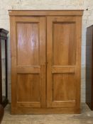An Edwardian ash linen press, the plain cornice over two panelled doors enclosing four slides, two