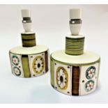 A pair of mid century pottery table lamps of squat bottle form decorated with stylised wheel and bar