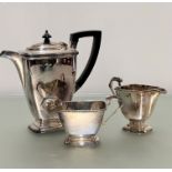 An Epns three piece tea service of rectangular tapered form with black handle to side and knop, (