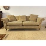 A contemporary scroll arm three seat sofa, upholstered in herringbone fabric, raised on turned front