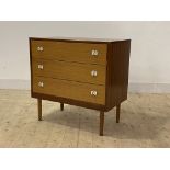 A mid century teak veneered chest, fitted with three drawers, raised on turned supports, H75cm,