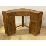 Heals, an oak corner writing desk, early 20th century, fitted with one long and four short