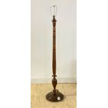 A turned walnut lamp standard, first half of the 20th century, with floral carved bands, on a