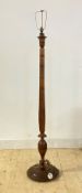 A turned walnut lamp standard, first half of the 20th century, with floral carved bands, on a