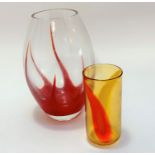 A handmade art glass oval vase with red cased starfish style interior and an amber and orange
