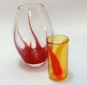 A handmade art glass oval vase with red cased starfish style interior and an amber and orange