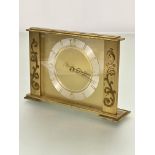 A mid century brass rectangular mantel clock with simple silvered bordered dial with Arabic numerals
