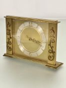 A mid century brass rectangular mantel clock with simple silvered bordered dial with Arabic numerals