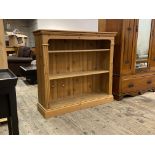 A late 20th century pine open bookcase, the two adjustable shelves flanked by reeded pilasters,