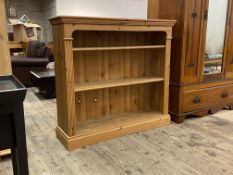 A late 20th century pine open bookcase, the two adjustable shelves flanked by reeded pilasters,