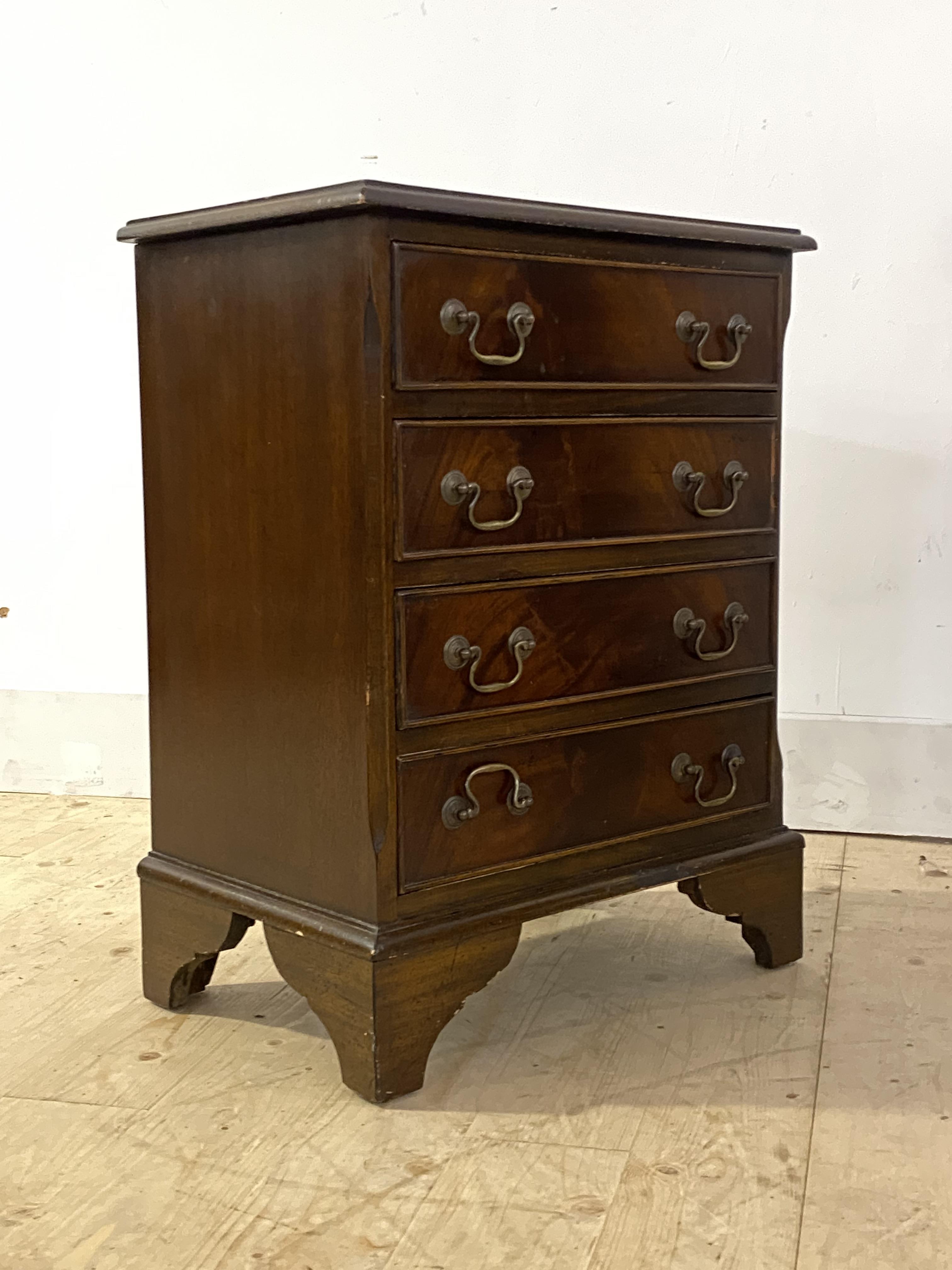 A Georgian style cross banded mahogany bedside chest, fitted with four drawers, raised on bracket