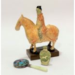 A pottery moulded figure of a Chinese rider on horseback, decorated with polychrome enamels, mounted
