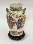 A Japanese pottery glazed twin handled baluster vase decorated with scenes of scholars with cherry
