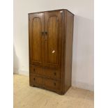A 20th century walnut compactum wardrobe, the two panelled doors enclosing shelves, over two drawers