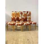 A set of four Andrew Martin contemporary dining chairs, upholstered in floral fabric, raised on
