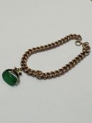 A 9ct gold curb link bracelet with clip fastening, mounted with green stone revolving 9ct gold seal,