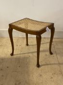 An early 20th century stained beech stool, with cane seat panel, standing on cabriole supports,