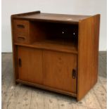 A mid century teak record cabinet, with two drawers, open shelf, twin sliding doors under