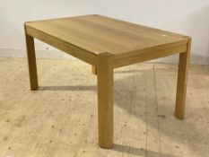 A contemporary light oak extending dining table, one end pulling out to accommodate two additional