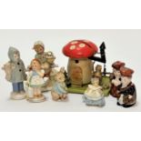 A treen figure on swing under a mushroom moneybox with picket style fence, some losses to paint