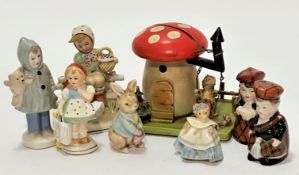 A treen figure on swing under a mushroom moneybox with picket style fence, some losses to paint