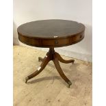 A Regency style mahogany drum table, the top inset with tooled leather writing surface, over four