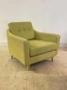 A contemporary easy chair, upholstered in buttoned lime green fabric, raised on turned supports,