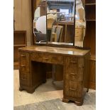 A 1920s walnut dressing table, the triple swing mirror back over one long and four short graduated